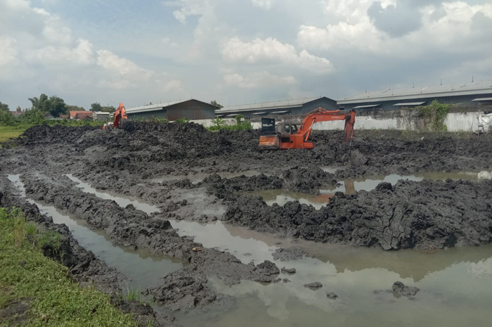 Petugas menormalisasi sedimentasi embung Dusun Tunggul, di Desa Tunggorono, Kecamatan Jombang.