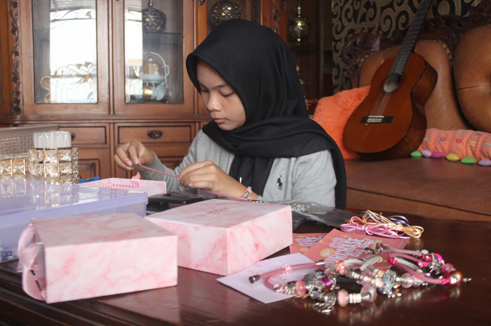 Child Lovely Azzahra Gaviota Rajiin sedang membuat gelang paracord di rumahnya