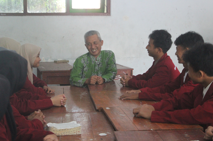 SERIUS: Guru Matematika SMPN 3 Jombang yang juga calon kepala sekolah, Atok Ansorit, berdiskusi dengan siswa di sekolah.
