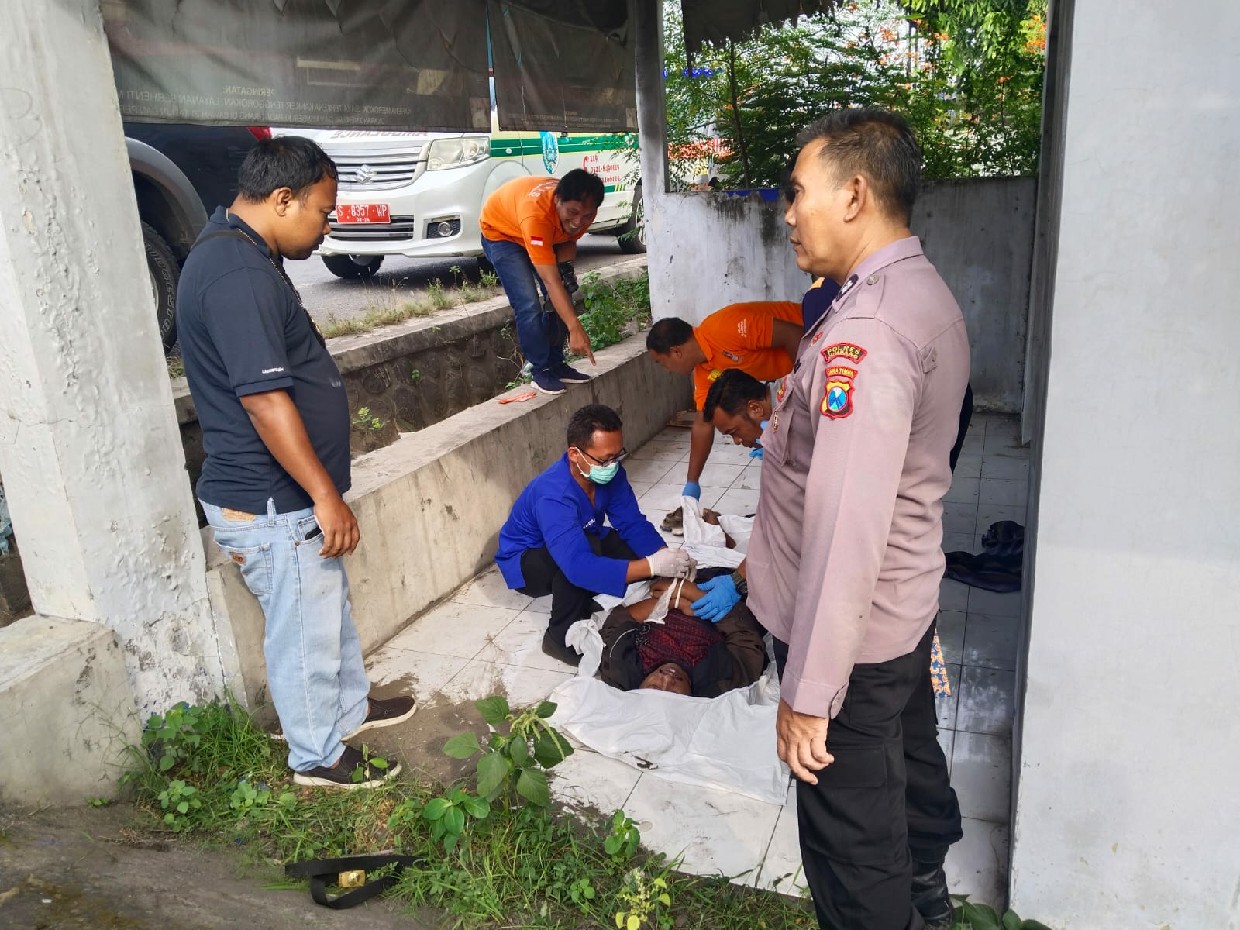 TKP: Petugas di lokasi penemuan pegawai Dinas Perhubungan Jombang, Raden Roby Hary Yanto, 45, meninggal di emperan rumah kosong Desa Palrejo, Sumobito, Jumat (18/4) pagi.