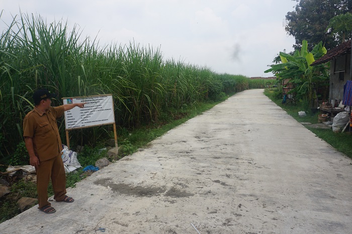 PERLANCAR AKSES WARGA: Salah satu perangkat Desa Menganto menunjukkan lokasi pembangunan jalan lingkungan rabat beton di Dusun Gempol Garut.