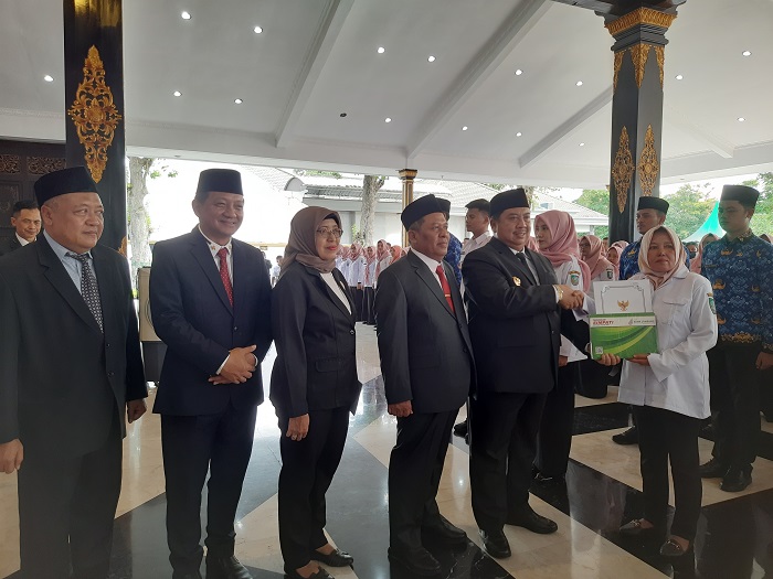 SENANG: Sulaminingsih menerima SK dari Bupati Warsubi di Pendopo Kabupaten Jombang, kemarin