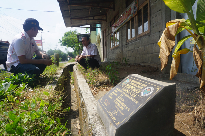 ATASI GENANGAN: Kepala Desa Penggaron Rikoret Hendrik (bertopi) didampingi perangkat desa saat menunjukkan lokasi pembangunan saluran drainase beton bertulang di Dusun Penggaron