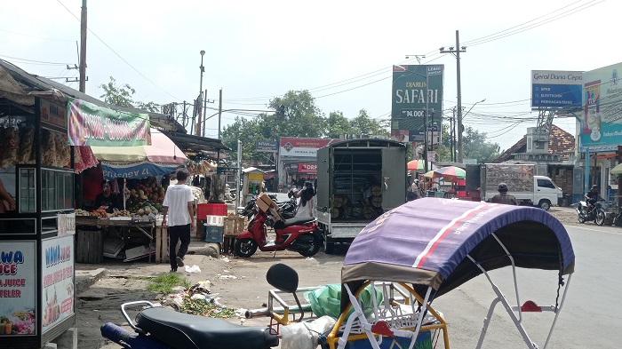 LUBER KE JALAN: Pedagang Pasar Ploso berjualan di pinggir jalan provinsi.