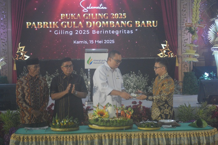 SUKSES: GM Djombang Baru, Adisolech Wicaksono, menerima potongan tumpeng dari Direktur Keuangan PT SGN, Hariyanto (batik), menandai buka giling 2025.