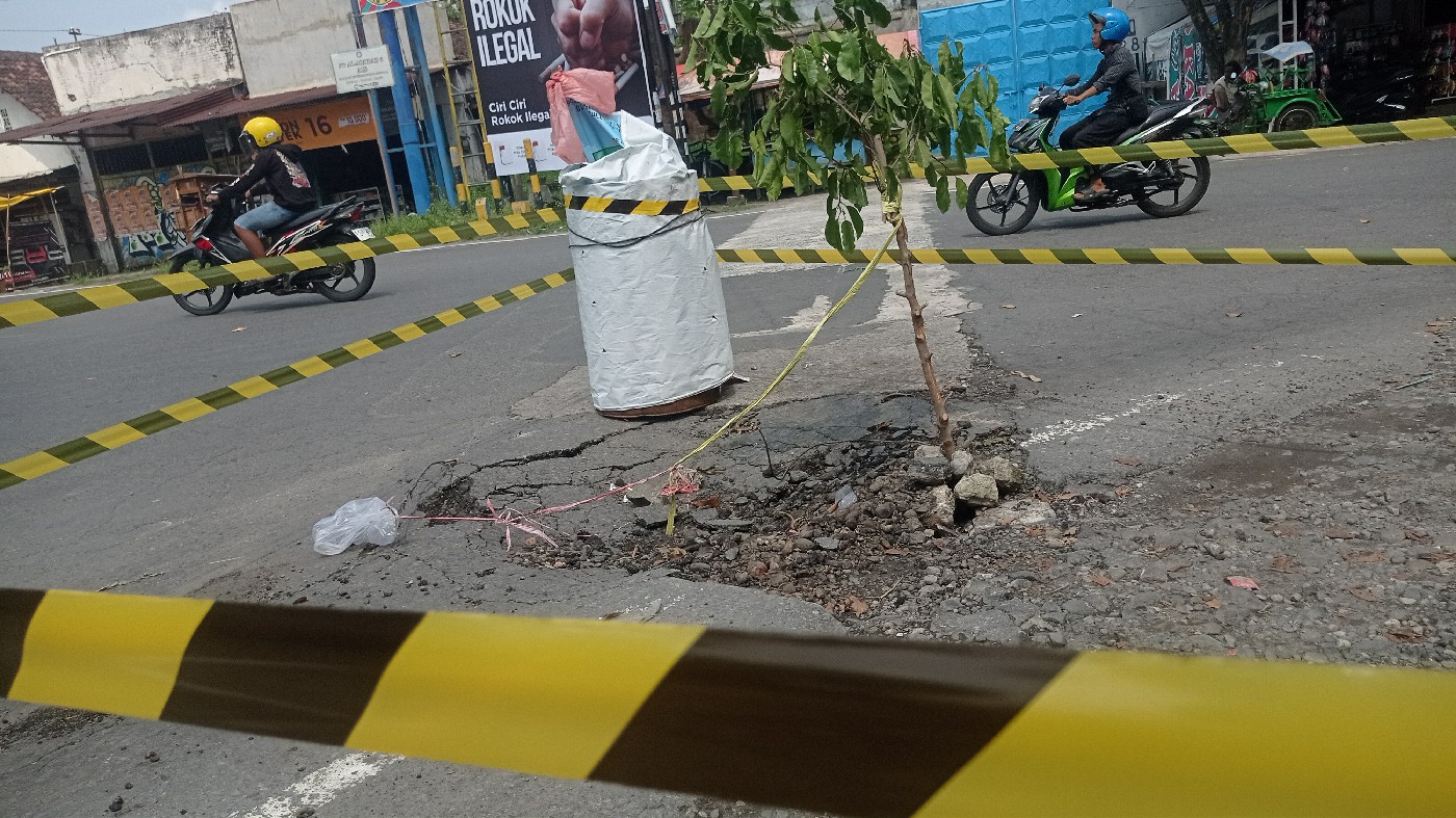 Jalan Kbaupaten di Desa Blimbing, Kecamatan Gudo Jombang yang ambrol ditandai drum bekas dan pita kuning-hitam (16/5).