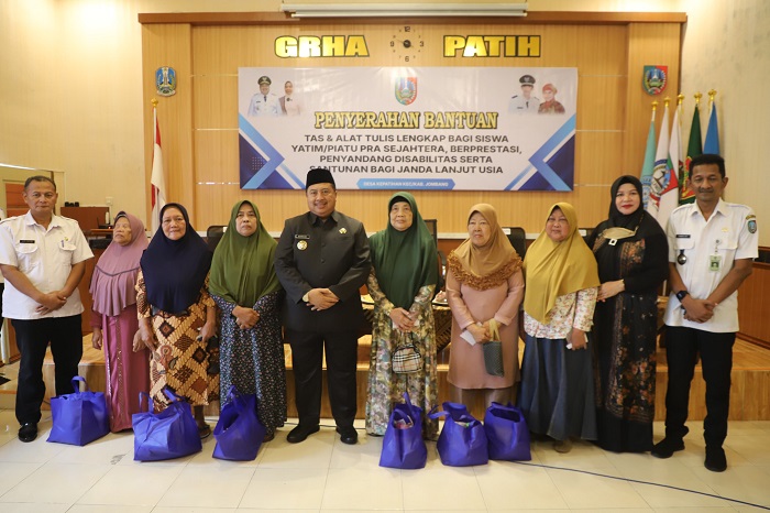 PEDULI: Bupati Jombang Warsubi mendampingi Erwin Pribadi Kades Kepatihan saat menyalurkan bantuan tas dan alat tulis sekolah, Rabu (28/5).