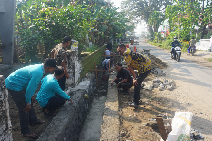 ATASI BANJIR: Kepala Desa Dukuhklopo Saiful Anam (paling kanan mengenakan batik) didampingi jajaran TPK Desa Dukuhklopo saat mengawasi pembangunan drainase