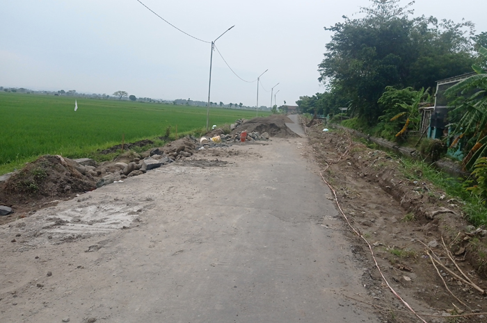 DIPERBAIKI: Jalan kabupaten ruas Pagerwojo-Banjarsari di Desa Pagerwojo, Kecamatan Perak dilakukan pelebaran (14/6).