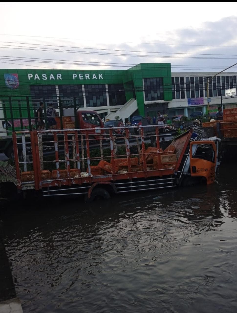 Kondisi truk muatan ayam yang nyemplung sungai depan Pasar Perak Jombang