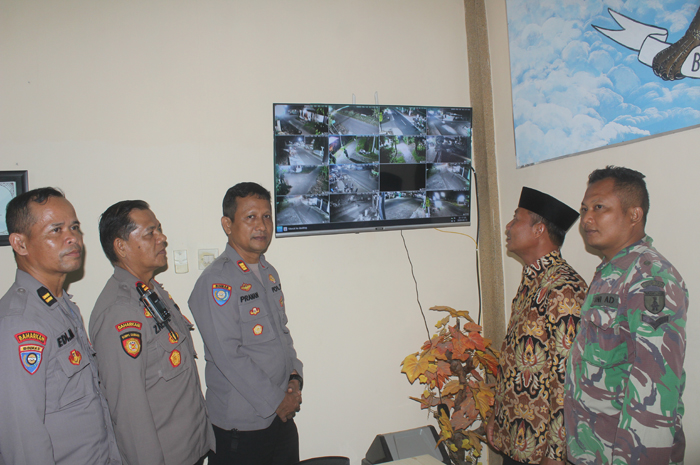 TERANG: Kasat Binmas Polres Jombang, AKP Pranan Edi, Kapolsek Bandarkedungmulyo Iptu Zaenal Abidin, Kades Muhammad Shony mengecek monitor  CCTV di Desa Pucangsimo, Kamis (12/6).