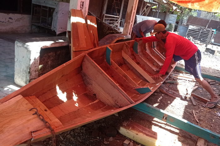 KREATIF: Wahib menyelesaikan pembuatan perahu sampan pesanan pelanggannya di Dusun Paras, Desa Turipingir, Kecamatan Megaluh.