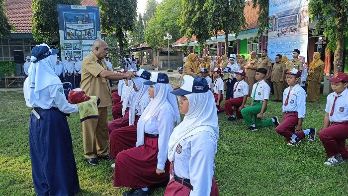 ANGKAT TOPI: Kepala SMPN 4 Jombang, Slamet Agus Tri Prastyo SPd, saat mengganti topi peserta MPLS sebagai simbol pergantian almamater dari SD ke SMP, Senin (14/7).