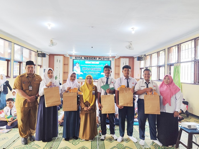 SEMANGAT: Kepala SMAN Ploso, Qoidatun Nisak, secara simbolis mengalungkan tanda peserta MPLS, kemarin.