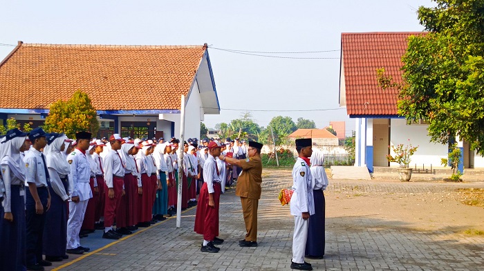 SIMBOLIS: Kepala SMPN 2 Mojoagung, Sugeng Wibowo MPd, menyematkan id card MPLS kepada siswa baru, kemarin.