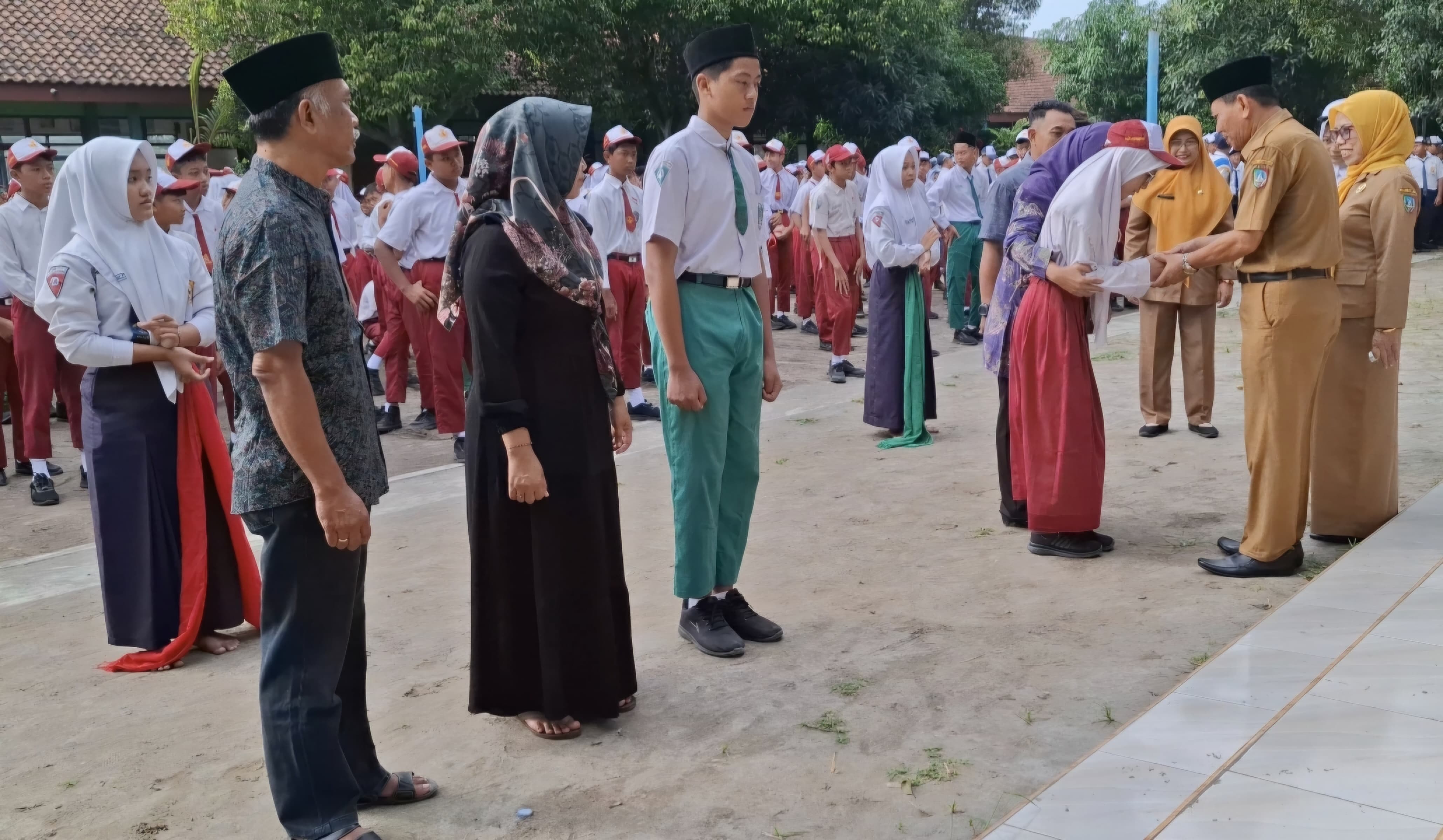 KOMPAK: Kepala SMPN 1 Ploso, Suryani MSi, mendampingi Pengawas SMP Dinas Pendidikan dan Kebudayaan Kabupaten Jombang, Drs Ghufron MSi, selaku pembina upacara pembukaan MPLS, Senin (14/7).