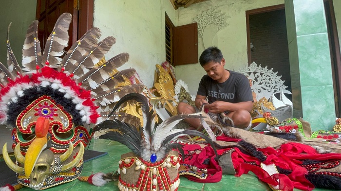 KREATIF: Hari Suciono, warga Desa Panglungan, Kecamatan Wonosalam saat membuat kreativitas kostum karnaval di rumahnya, kemarin (16/7).