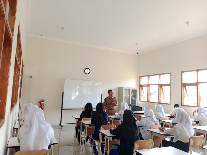 MENGABDI: Andik Minarto, Kepala Sekolah Rakyat Jombang saat mengisi materi dalam kelas.