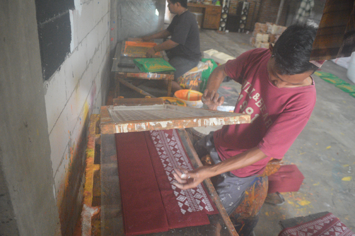 DIPOTONG: Pekerja memotong lembaran kain spon bon produksi tas hajatan di Desa Budugsidorejo, Kecamatan Sumobito.
