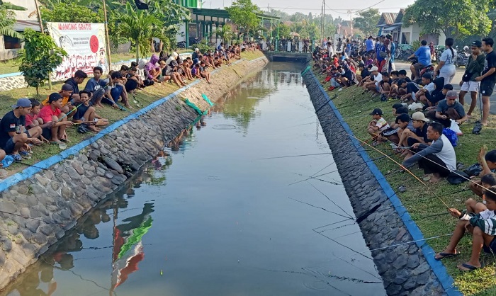 MERIAH: Masyarakat meramaikan mancing gratis yang digelar Kartar Kecamatan Mojoagung di Dam Brantas Penanggalan, Desa Dukuhdimoro, Minggu (3/8).