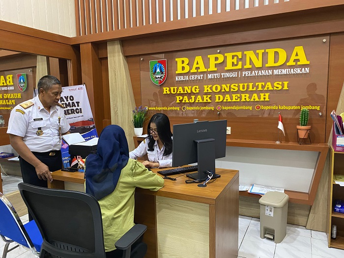 LAYANI WARGA: Kepala Bapenda Jombang Hartono mendampingi warga yang mengajukan keberatan tarif PBB-P2 di kantor Bapenda Jombang, Rabu (20/8).