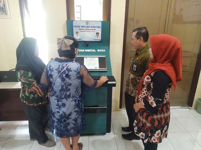 LAYANAN DIGITAL: Kepala Desa Pulosari Nefi Ufus Solikah bersama Camat Bareng Usman mendampingi salah satu warga saat melakukan pelayanan secara digital.