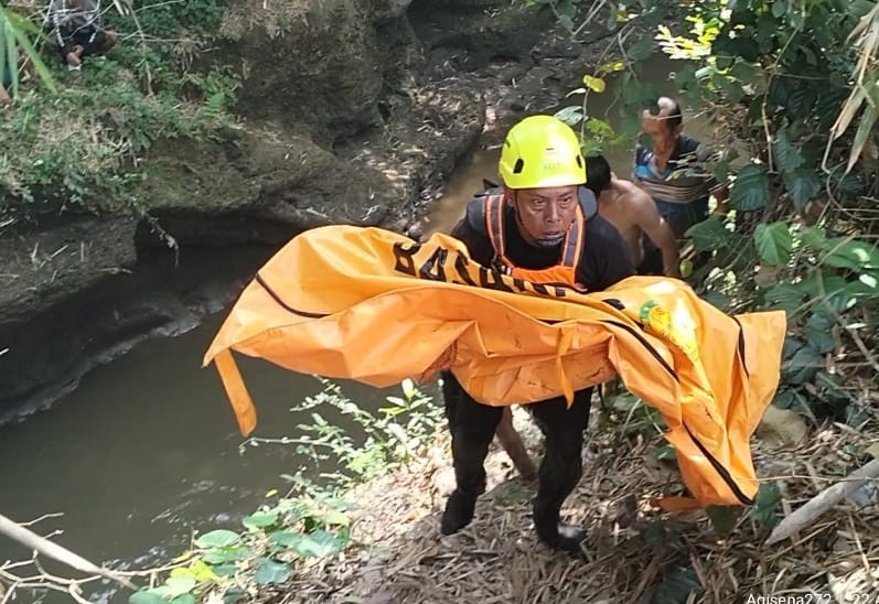 Petugas BPBD Jombang saat mengevakuasi jasad korban dari dalam sungai