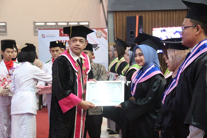 3.	Wakil Rektor Bid Kerjasama & Pengembangan H. M. Zahrul Azhar, SIp M.Kes saat menyerahkan cinderamata kepada wisudawan terbaik akademik