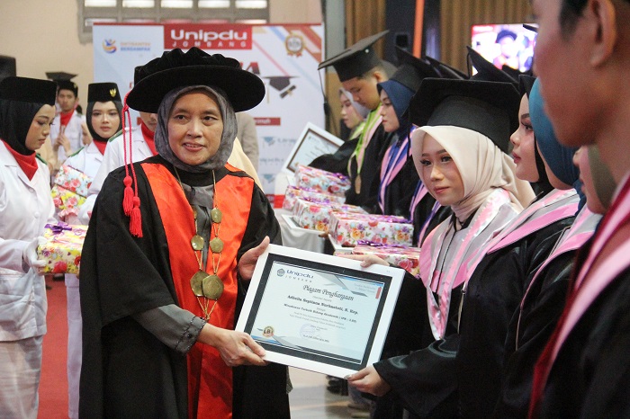 2.	Wakil Rektor Bidang SDM, Keuangan & Umum Hj Uswatun Qoyyimah SS MEd Ph.D saat menyerahkan cinderamata kepada wisudawan terbaik akademik