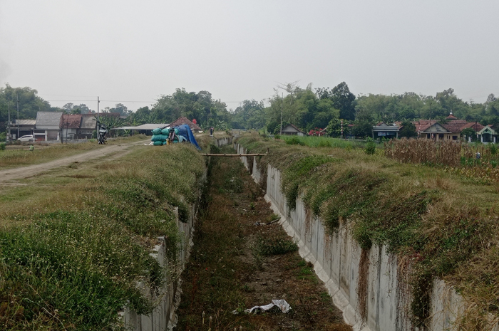 BELUM TUNTAS: Pekerja beraktivitas di irigasi Pariterong di Desa Balongbesuk, Kecamatan Diwek.