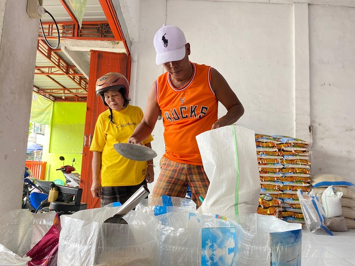 NAIK: Sugandi, salah satu pedagang beras di Pasar Citra Niaga (PCN) Jombang saat melayani pembeli, Selasa (26/8).