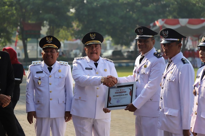 Bupati Jombang Warsubi memberikan penghargaan kepada Kepala Desa (Kades) Pandanwangi Asan dalam upacara HUT Kemerdekaan RI ke-80 di Alun-alun Jombang, Minggu (17/8)