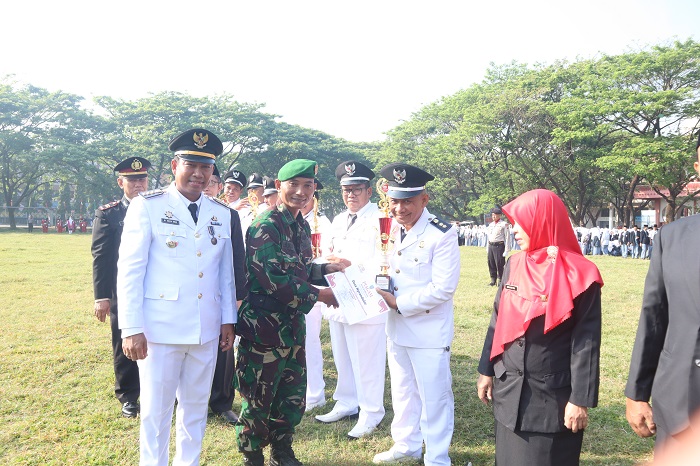 Dwi Aris S./Jawa Pos Radar Jombang  APRESIASI TRANTIBUM: Kepala Desa Ngrandulor Mohammad Rofiudin menerima piala penghargaan dari perwakilan Koramil 0814/13 Peterongan saat upacara peringatan
