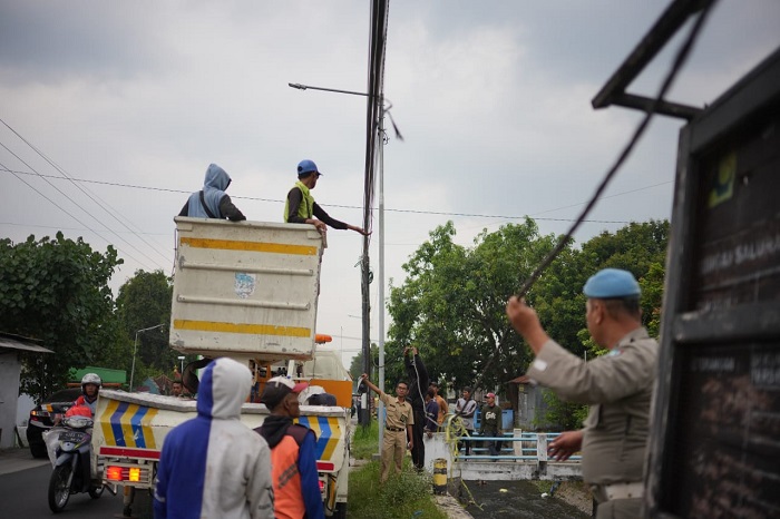 DITERTIBKAN: Petugas gabungan menertibkan keberadaan kabel fiber optic yang semrawut kemarin.  &nbsp;