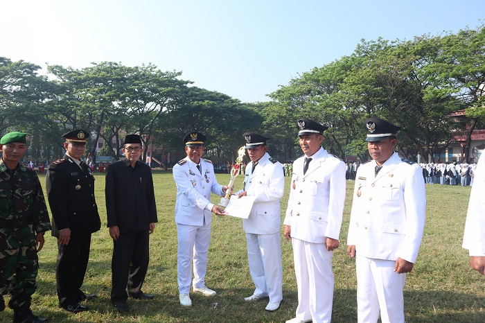 APRESIASI KINERJA: Kepala Desa Sumberagung Shodiqin menerima piala penghargaan dari Camat Peterongan Mohammad Eryk Arif saat upacara peringatan HUT Kemerdakaan RI