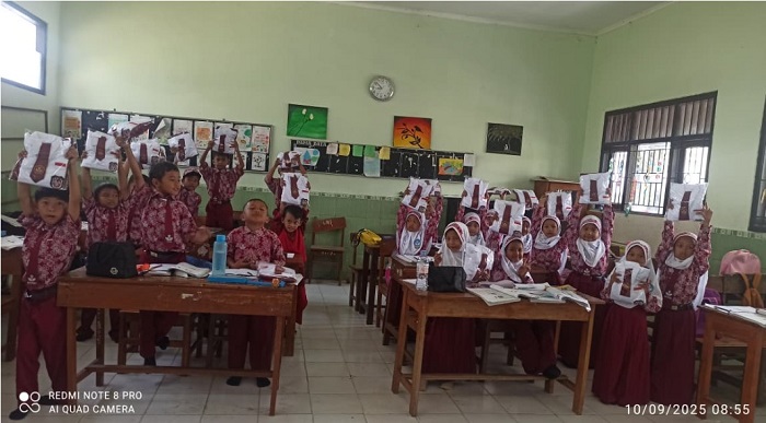 SENANG: Siswa SD di Kecamatan Perak menerima seragam gratis (16/9).  &nbsp;