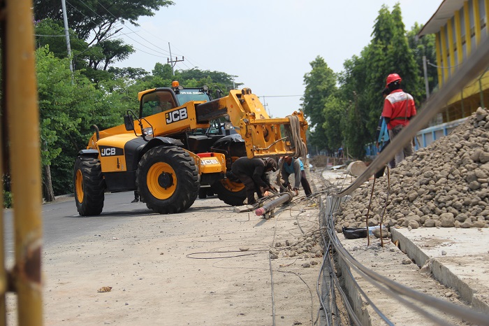 DICABUT: Dinas PUPR menggunakan alat telehandler untuk mencabut tiang internet di Jl Gubernur Suryo dan Jl Kusuma Bangsa, kemarin (13/10).