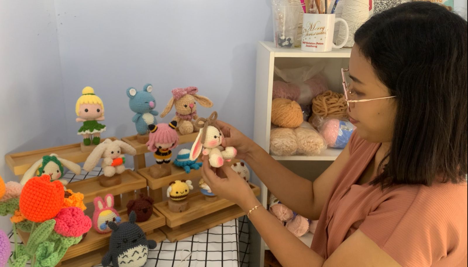 Yuli Kristiani, saat membuat boneka rajut di rumahnya