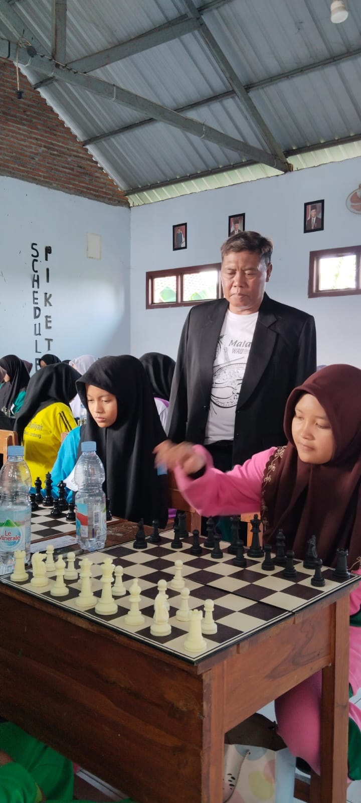 Wahyudi, saat memantau pertandingan catur di MTs Darul Ulum Bandung Kecamatan Diwek