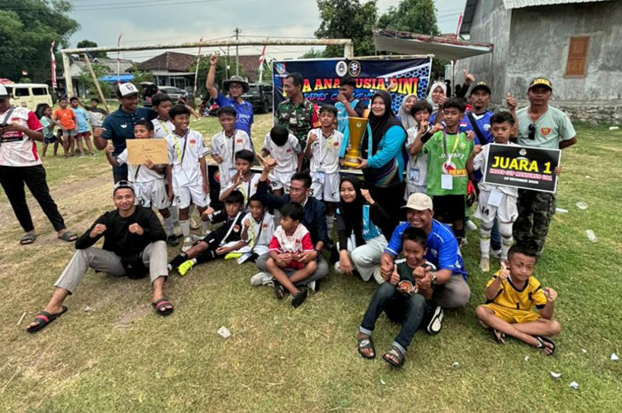 EVENT PERDANA: Kepala Desa Menturus Nyamiati memberikan piala juara Kades Cup Menturus kelompok usia 11 tahun kepada tim Putra Gama Gadingmangu, Perak, Minggu (19/1