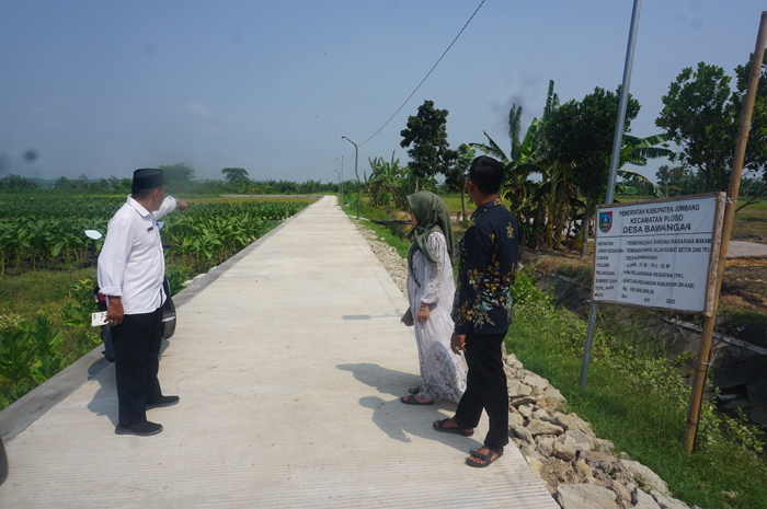 UNTUK WARGA: Kepala Desa Bawangan Bakhtiar Effendi didampingi jajaran perangkat desa saat menunjukkan lokasi pembangunan jalan rabat