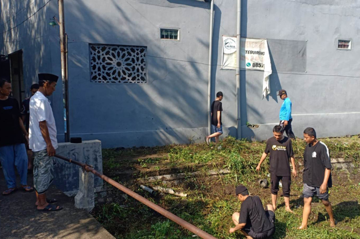 KOLABORASI PEDULI LINGKUNGAN: Kepala Desa Cukir Sawung Agus Basuki memantau kegiatan bersih-bersih lingkungan di wilayah Dusun Tebuireng.