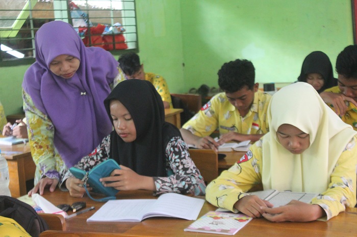 SEMANGAT: Nurul Afrida, pembimbing muatan lokal pendidikan diniyah yang belum diangkat menjadi PPPK paruh waktu saat mengajar di SMPN 1 Perak, (13/11).  &nbsp;