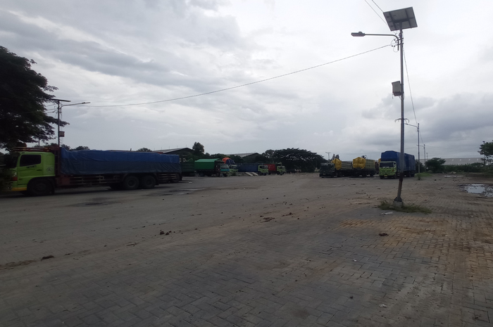 SEGERA DITUTUP: Petugas memasang banner di eks Terminal Barang Desa Tunggorono, Kecamatan Jombang.
