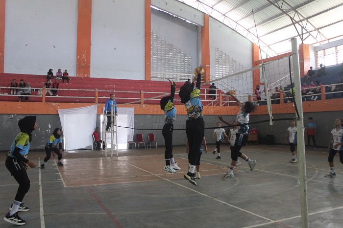 SERU: Pertandingan tim SMPN 2 Prambon Sidoarjo (putih) melawan MTsN 5 Kediri (biru) di GOR Merdeka, Rabu (19/11). MTsN 5 Kediri menang 2-0.