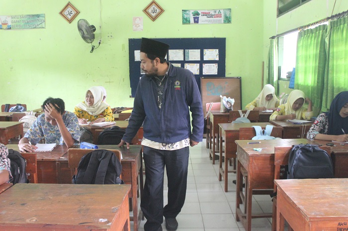 SEMANGAT: Luqmanul Hakim, pembimbing diniyah yang diangkat menjadi PPPK paruh waktu saat mengajar di ruang kelas SMPN 1 Perak.
