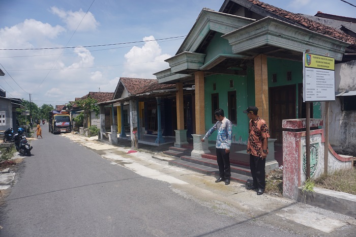 KOKOH DAN RAPI: Sekretaris Desa Rejosopinggir Rakhmat Eko Cahyono (batik coklat) dan anggota TPK Desa Rejosopinggir Dedy Kuswanto menunjukkan lokasi pembangunan
