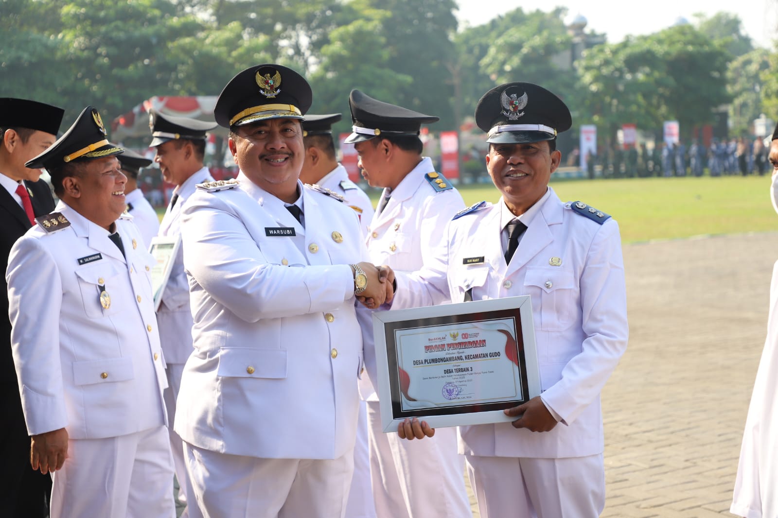 APRESIASI: Kepala Desa Plumbon Gambang Nur Wakit saat menerima piagam penghargaan dari Bupati Jombang Warsubi sebagai salah satu desa berkinerja baik dalam PKTD tah