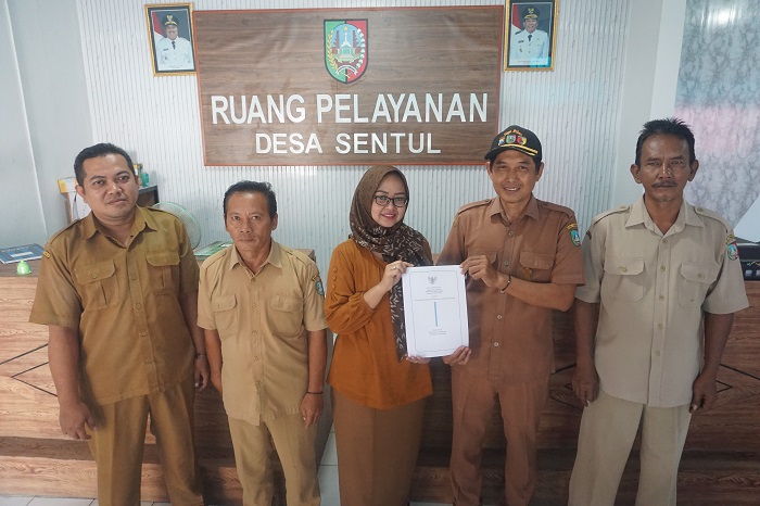 KOMITMEN: Kepala Desa Sentul Misbahul Arifin didampingi jajaran perangkat Desa Sentul saat menunjukkan Perdes Ramah Perempuan dan Peduli Anak.