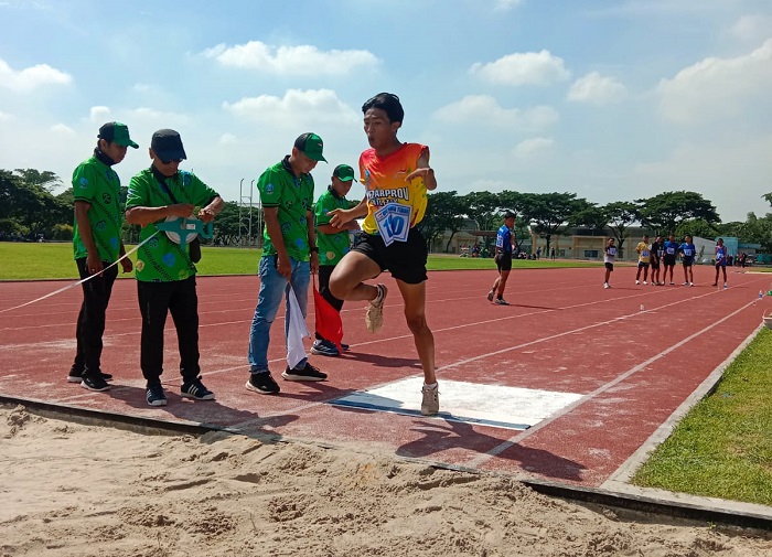 JUARA: Muhammad Zaini meraih medali emas nomor lompat jauh Keparprov Jatim di lapangan atletik Unesa Surabaya, Minggu (7/12).